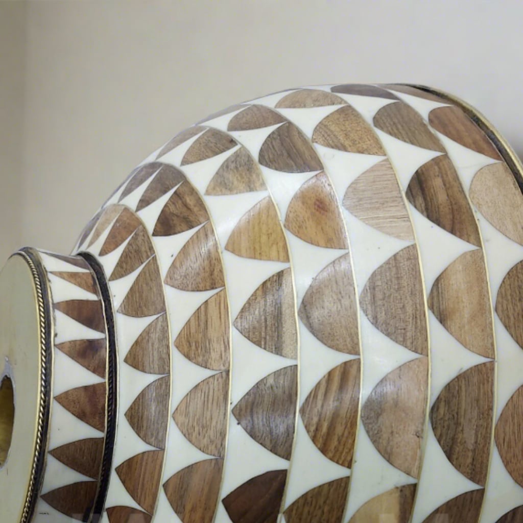 Side profile of a handcrafted brass bowl sink with brown and white mosaic accents, highlighting the luxurious design and smooth brass finish