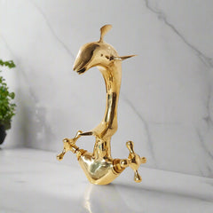 Dolphin-shaped brass faucet with polished smooth finish on marble background