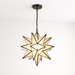Illuminated Moravian star pendant light with frosted glass panels and black metal frame, suspended by a chain from the ceiling