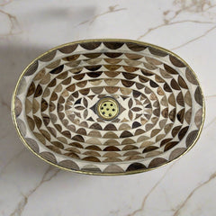 Close-up of a brown and white handcrafted Moroccan brass sink showcasing intricate hand-etched geometric patterns