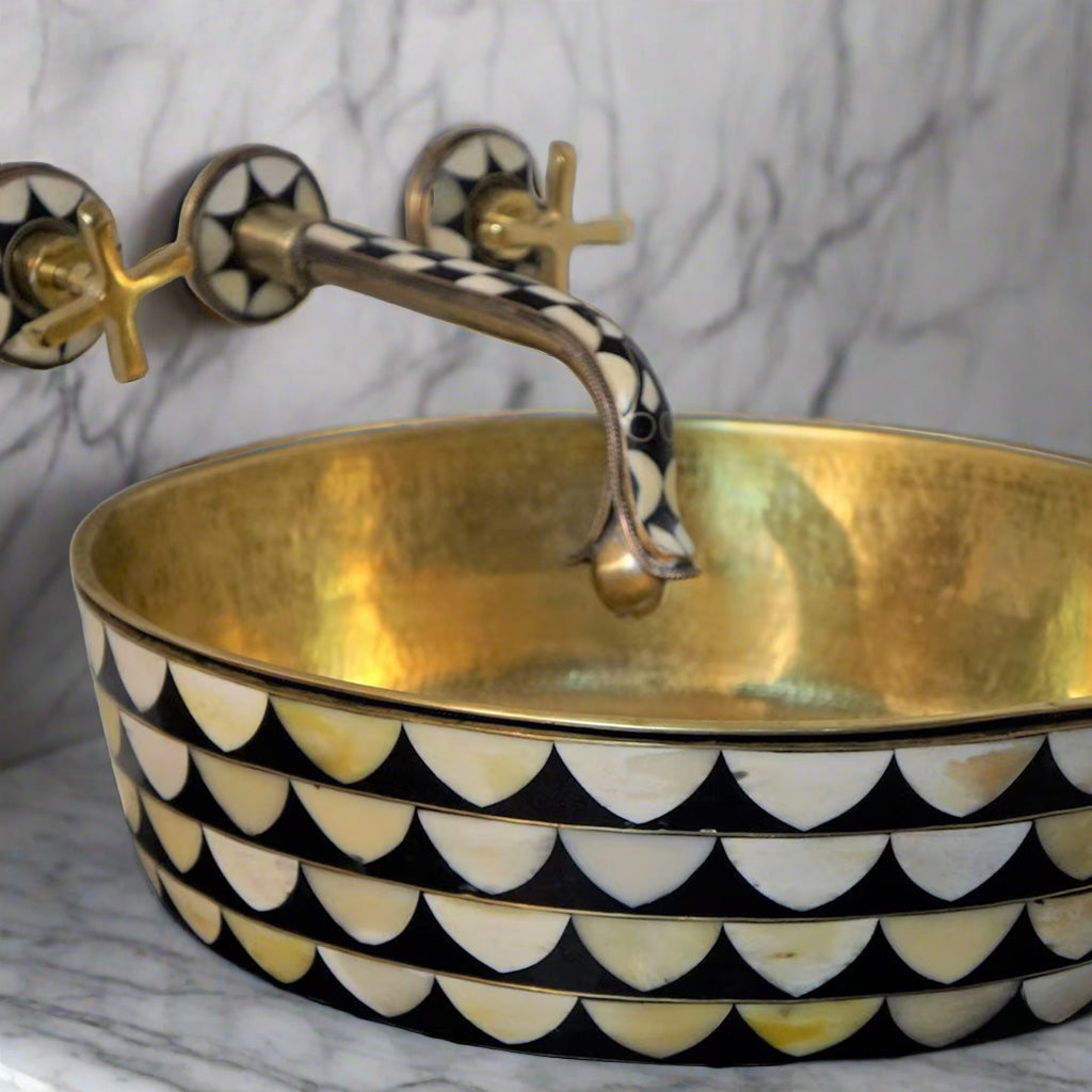 Side angle of the resin and brass bathroom sink showing the detailed mosaic pattern and the reflection of light on the hammered brass interior